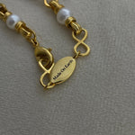Angel Aberdeen – Forever Connected necklace – detail view showing brand tag with Made On Earth engraving in 18k PVD gold plating with enamel inlay and pearl accents
