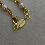 Angel Aberdeen – Forever Connected necklace – detail view showing brand tag with Made On Earth engraving in 18k PVD gold plating with enamel inlay and pearl accents