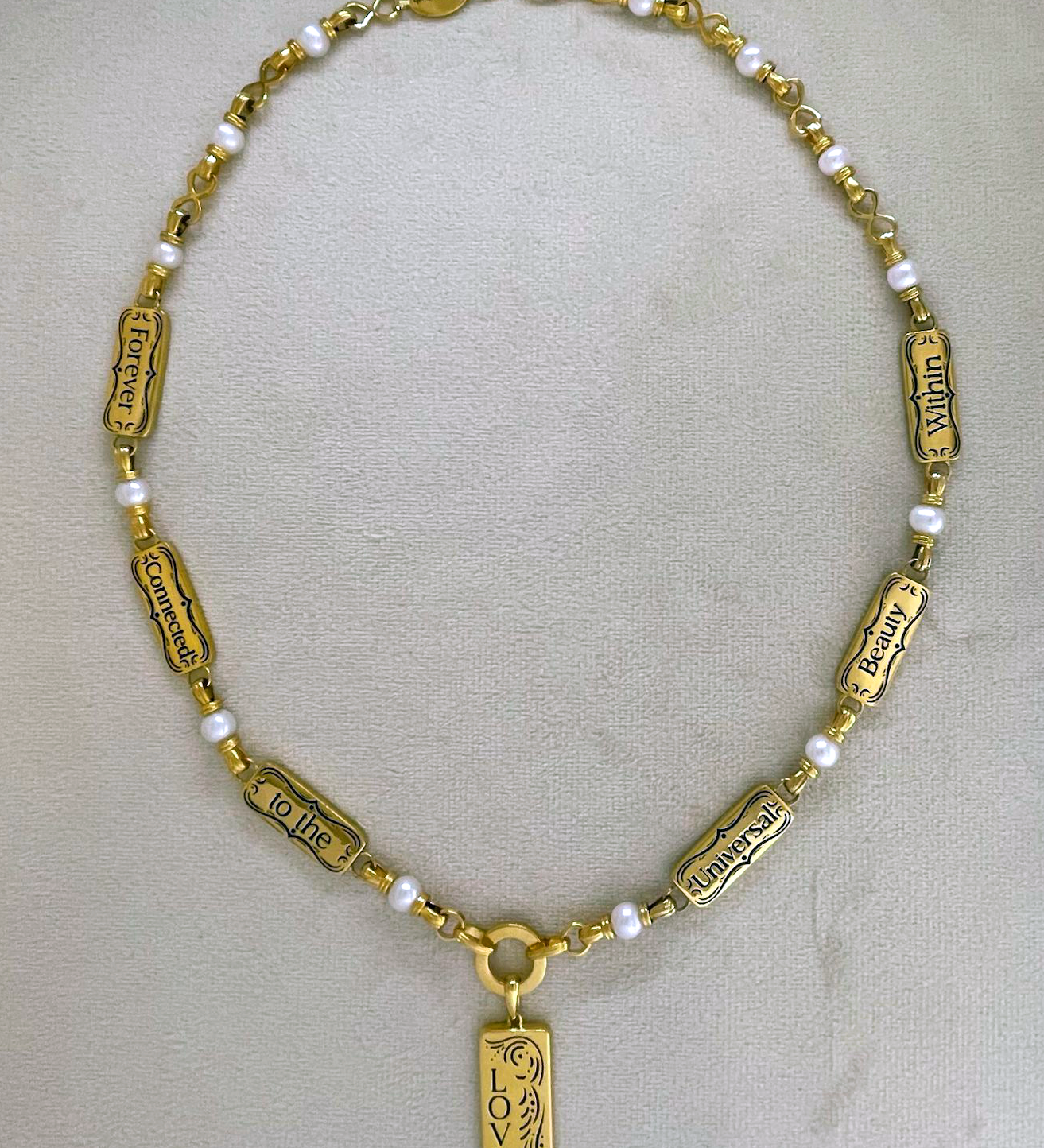 Angel Aberdeen – Forever Connected necklace – 18k PVD gold plated with enamel inlay – backside view showing engraved affirmations including Love and the phrase Forever Connected to the Universal Beauty Within