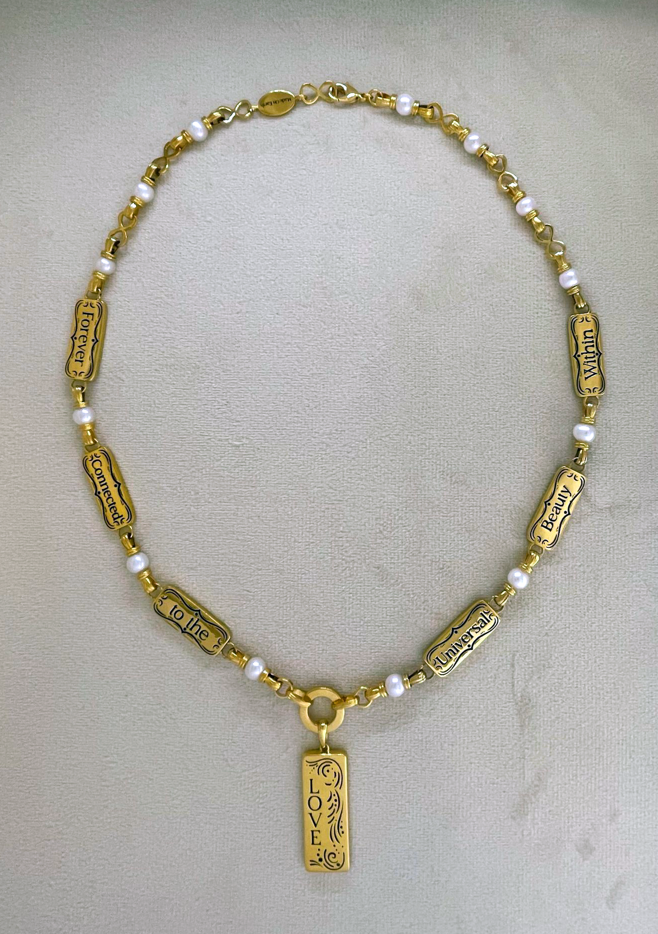 Angel Aberdeen – Forever Connected necklace – 18k PVD gold plated with enamel inlay – backside view showing engraved affirmations including Love and the phrase Forever Connected to the Universal Beauty Within