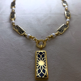 Angel Aberdeen – Forever Connected station necklace – 18k PVD gold plated with black enamel inlay and pearls – front view with sacred geometric torus pendant and linked design