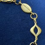 Detail of engraved “Made on Earth” tag beside lobster clasp on the gold-plated Sacred Mandorla Bracelet by Angel Aberdeen.
