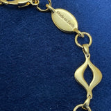 Detail of engraved “Made on Earth” tag beside lobster clasp on the gold-plated Sacred Mandorla Bracelet by Angel Aberdeen.