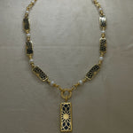 Angel Aberdeen – Forever Connected station necklace – 18k PVD gold plated with black enamel inlay and pearls – front view with sacred geometric torus pendant and linked design