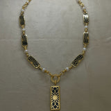 Angel Aberdeen – Forever Connected station necklace – 18k PVD gold plated with black enamel inlay and pearls – front view with sacred geometric torus pendant and linked design