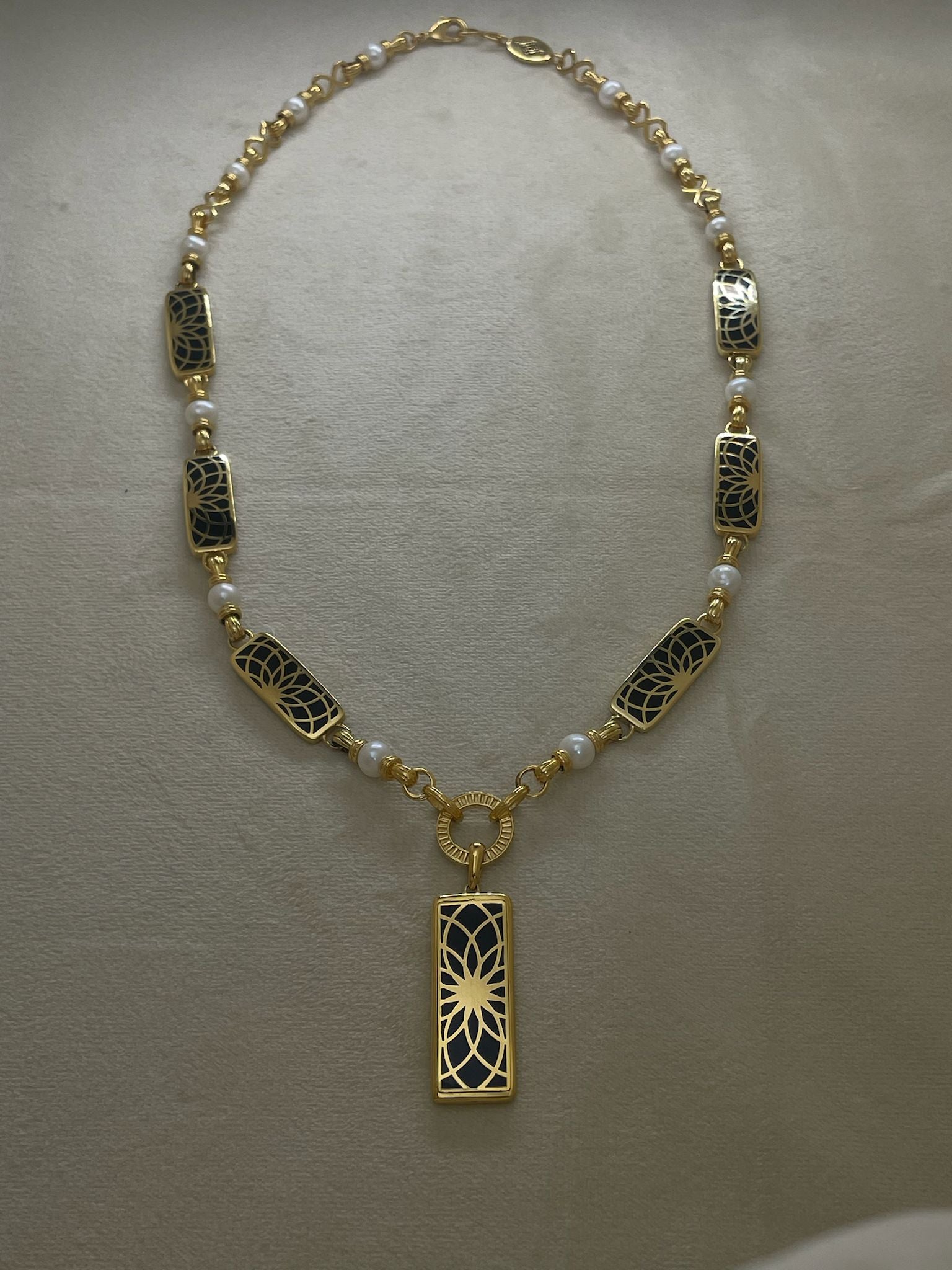 Angel Aberdeen – Forever Connected station necklace – 18k PVD gold plated with black enamel inlay and pearls – front view with sacred geometric torus pendant and linked design